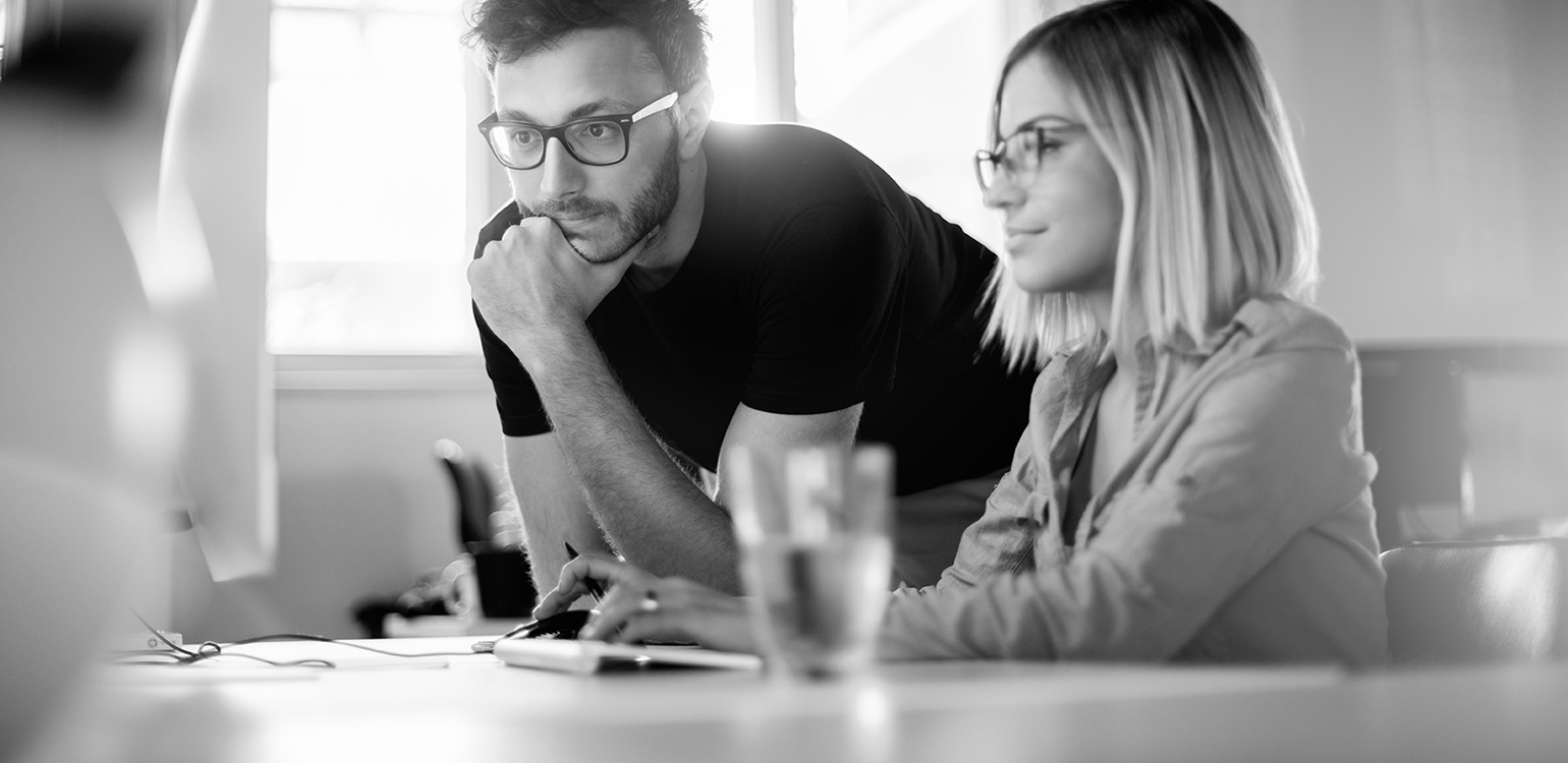 Woman and man looking at computer monitor